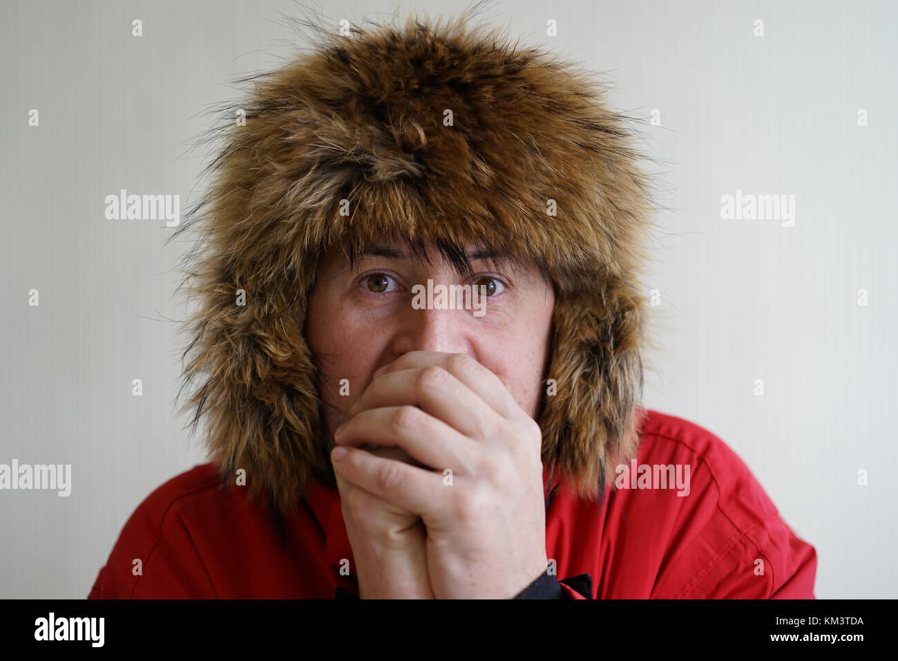 Giovane uomo si è bloccato in un cappello di pelliccia Foto Stock