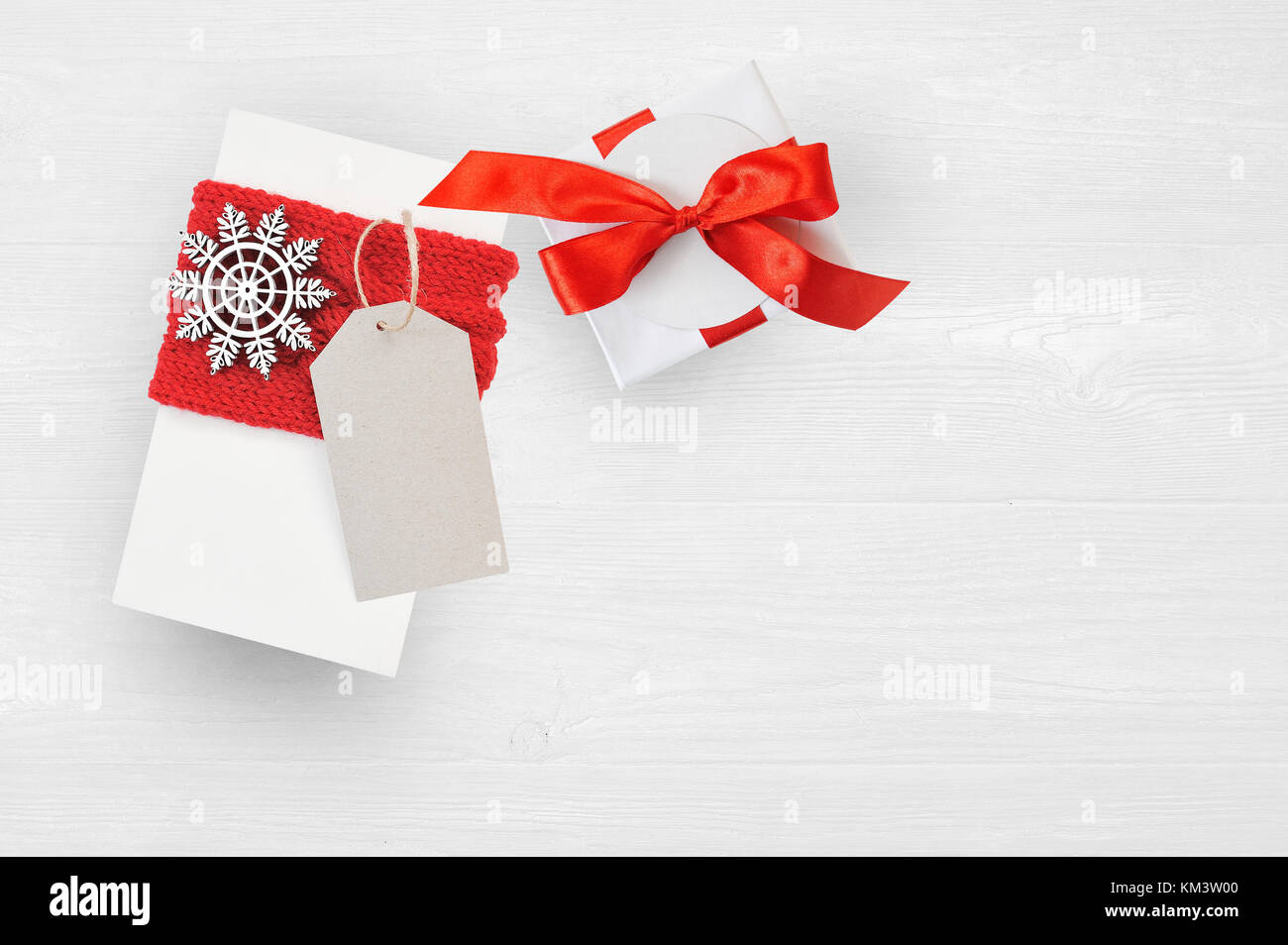 Mockup regalo di Natale scatola e tag su sfondo di legno con i fiocchi di neve, biglietto di auguri buon Natale e felice anno nuovo Foto Stock