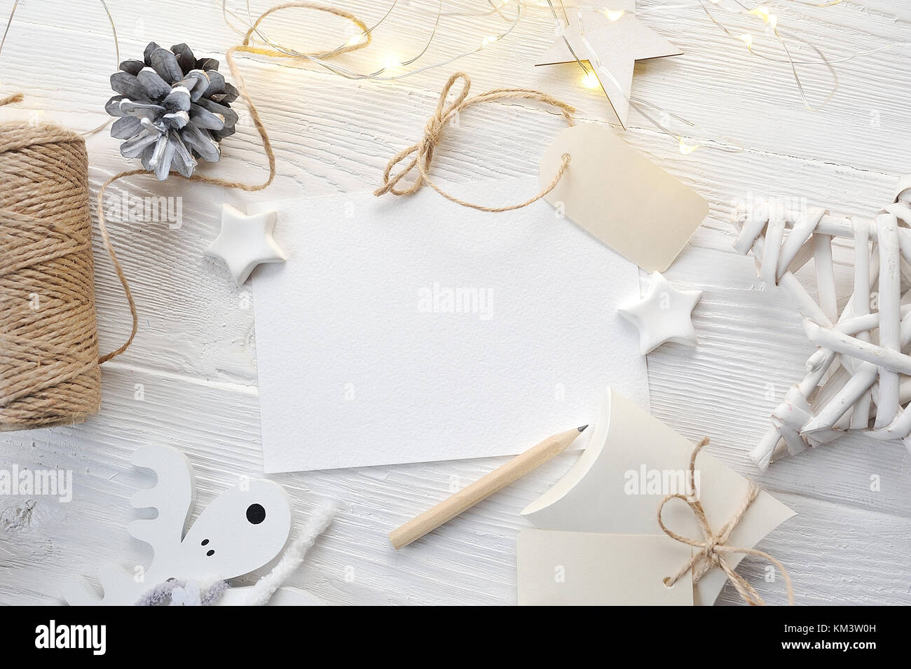 Mockup natale greeting card top view, flatlay su un bianco sullo sfondo di legno con una ghirlanda di fiori Foto Stock