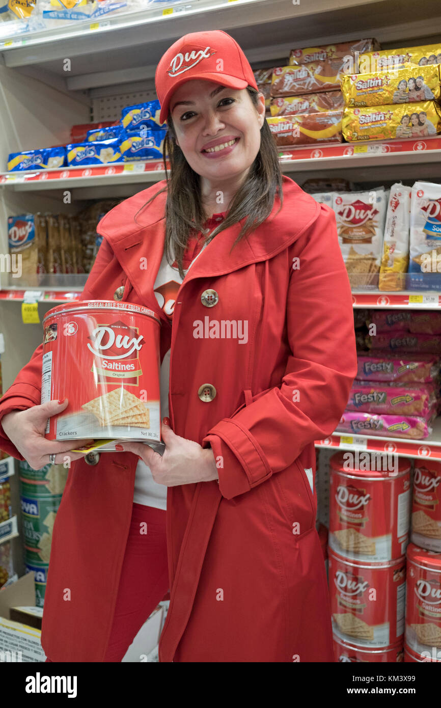 Una bella donna latinoamericana promuovere Dux cracker al bazar del cibo al supermercato in città di Long Island che si specializza in invii internazionali Foto Stock