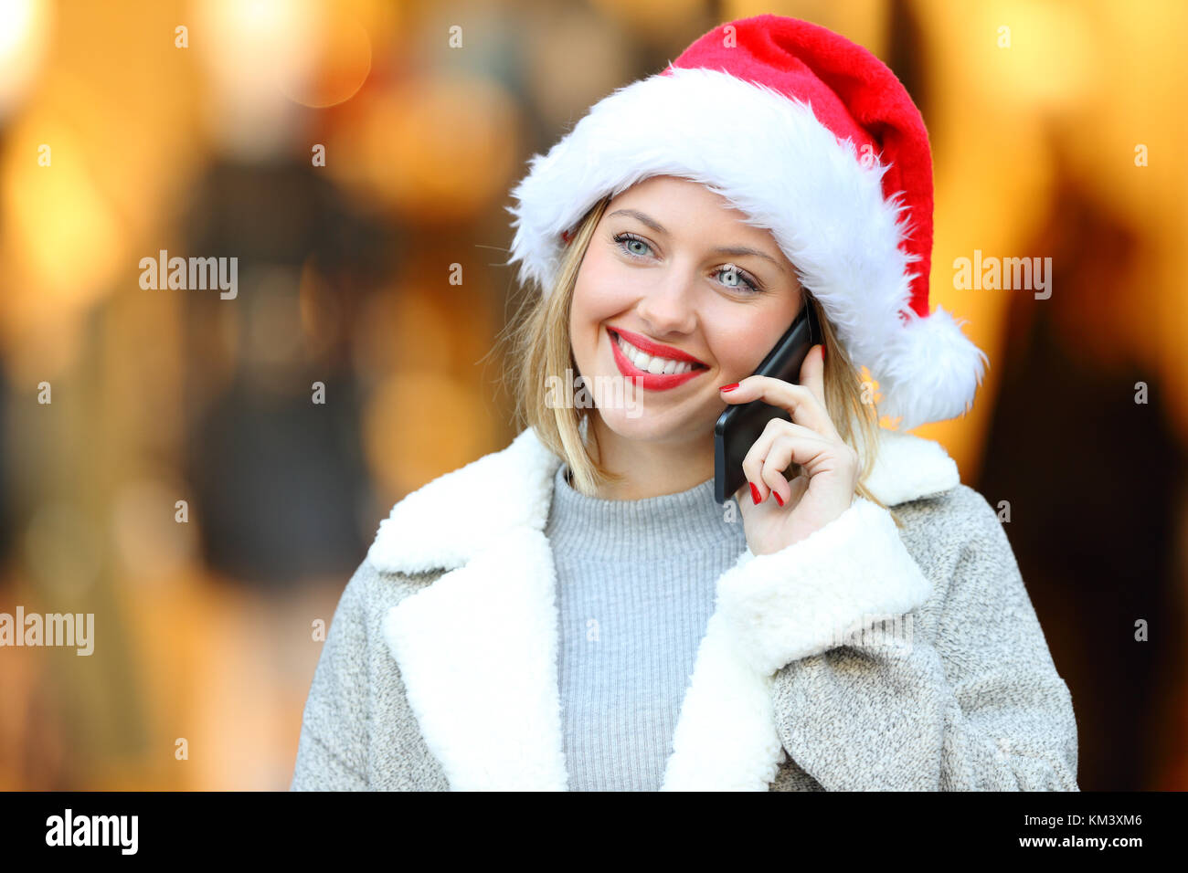 Vista frontale il ritratto di una donna felice chiamando sul cellulare in vacanze di Natale sulla strada Foto Stock