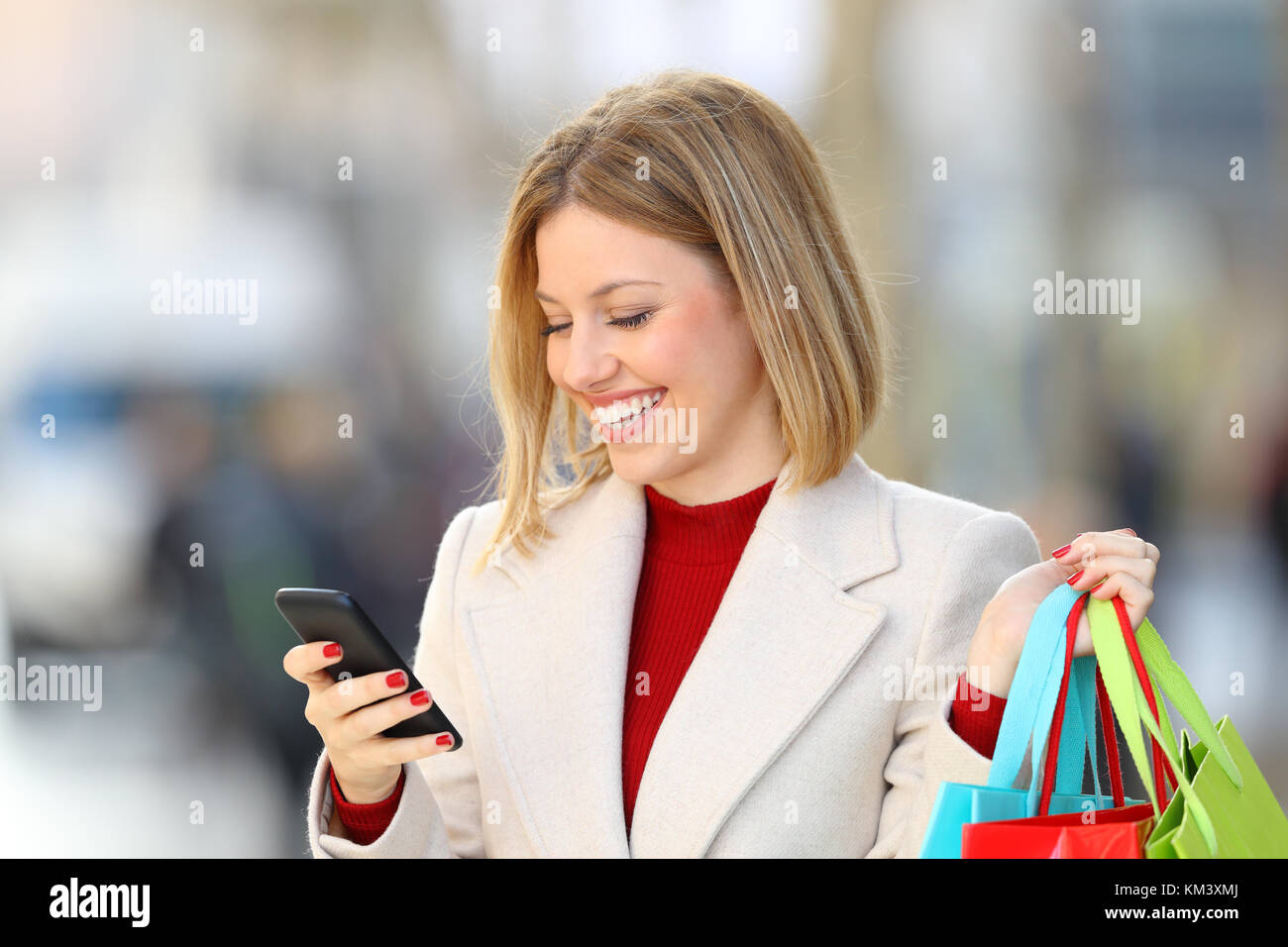 Ritratto di un acquirente acquisti on line azienda borse per lo shopping sulla strada in inverno Foto Stock
