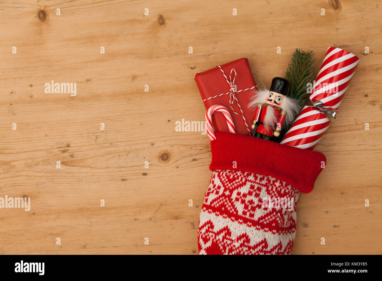 Calza di Natale con cracker, giocattolo e avvolti presente Foto Stock