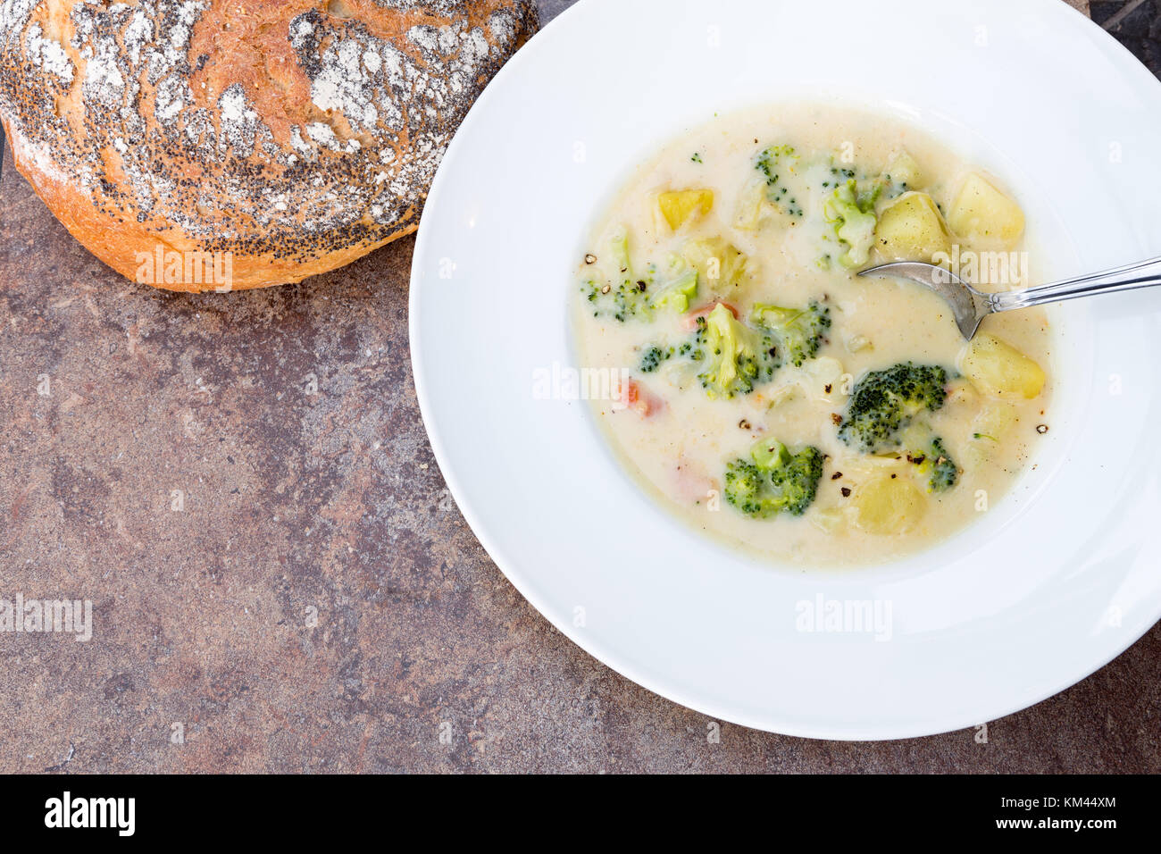 Una grande ciotola bianco casereccio broccoli cremosa ,potato ,formaggio e pancetta minestra con un rustico di crosta di pane e verdure Foto Stock