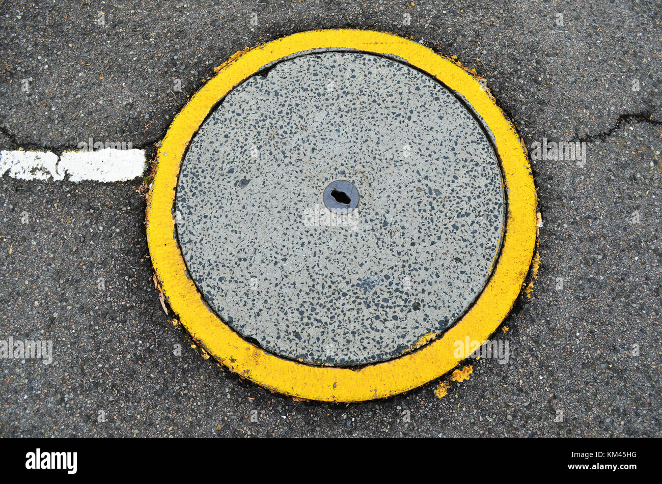 Cerchio giallo attorno all uomo foro del coperchio di scarico in strada Foto Stock
