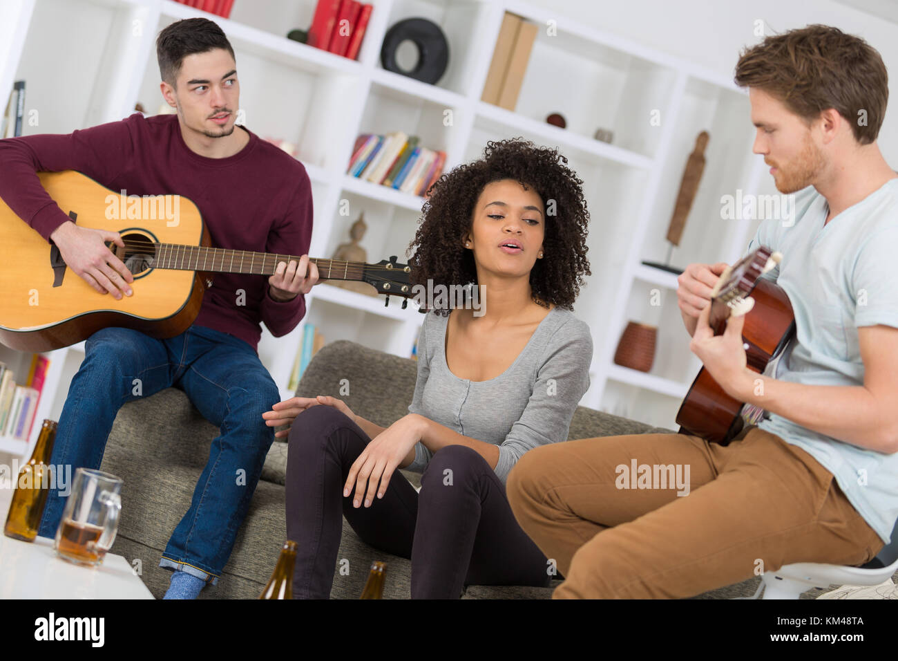 Gruppo di amici di riproduzione di musica con una chitarra Foto Stock