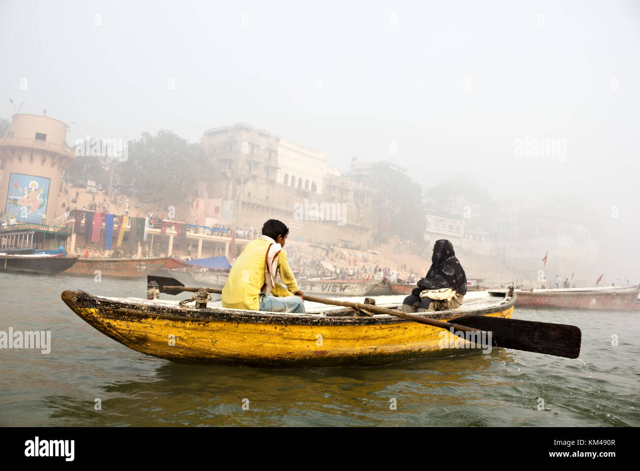 Un turista straniero godendo della vista dei ghats dal santo gange touring su una riga di legno barca, Varanasi, Benares, kashi, India Foto Stock
