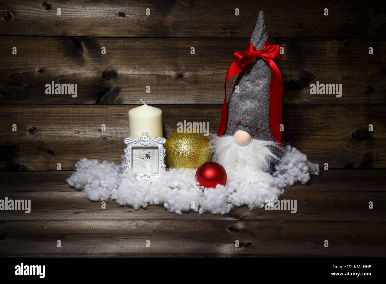 Decorazione di natale con candela, picture frame, sfere, neve & scandinavian gnome tomte, nisse, tomtenisse, tonttu con nastro su sfondo di legno. Foto Stock