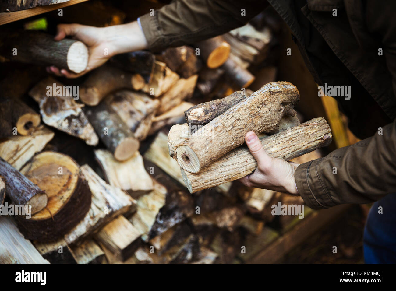 Un uomo i registri di impilamento, legno di diverse lunghezze. un negozio di legna da ardere. Foto Stock