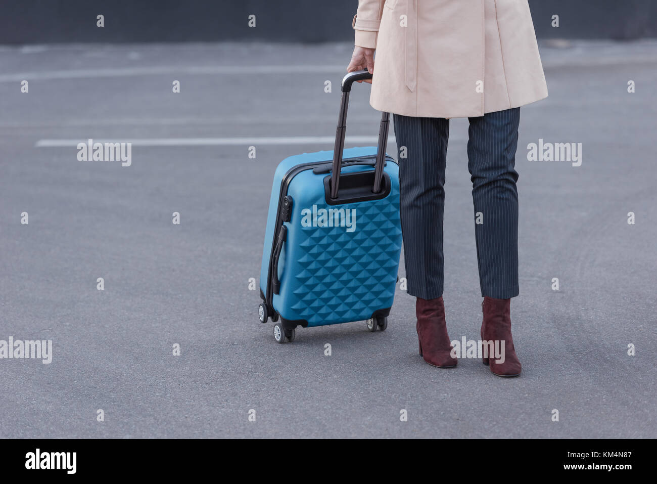 La donna a trench coat con la valigia Foto Stock