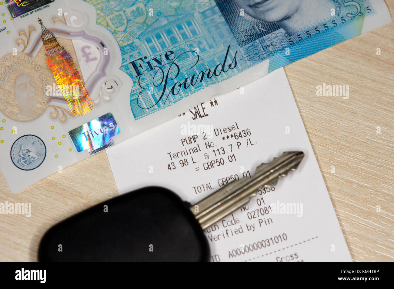 Il carburante diesel ricevuta in libbre con contanti e chiave auto Foto Stock