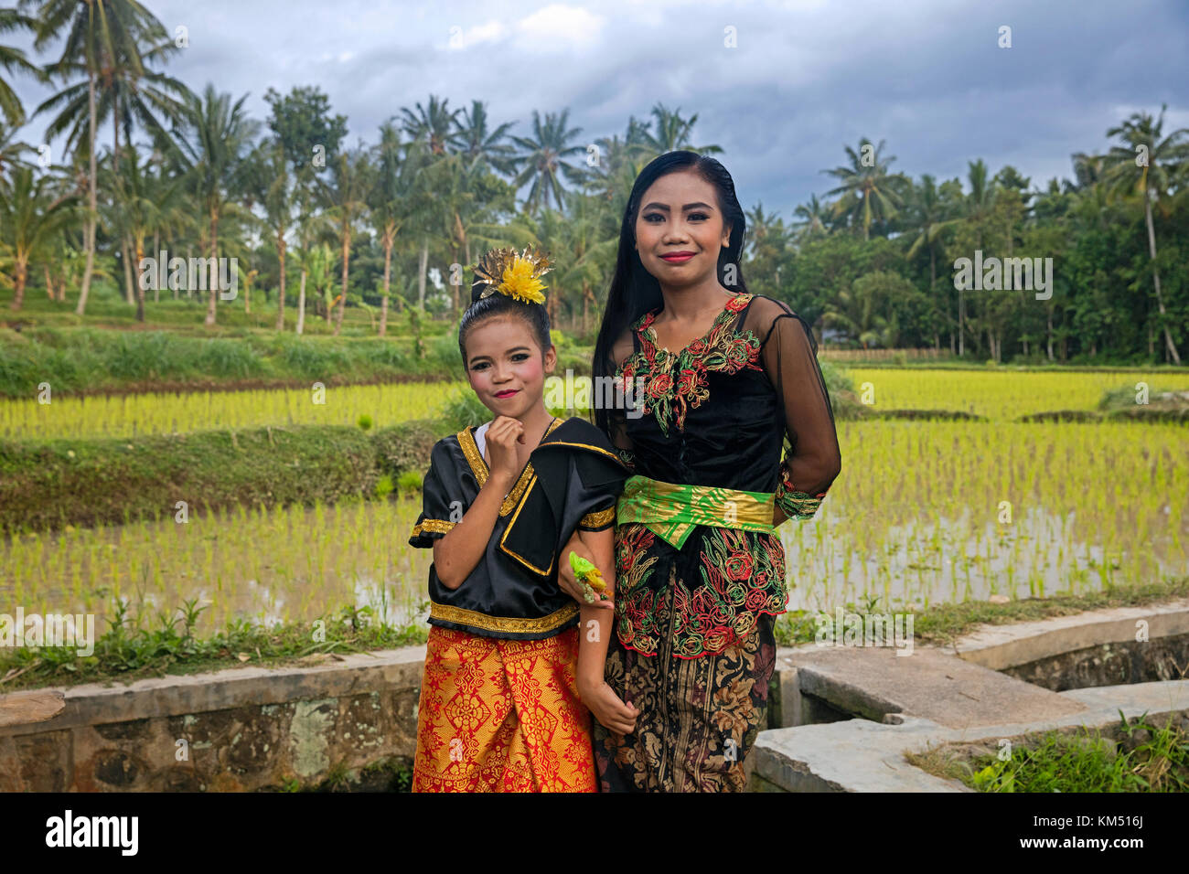 Giovane donna e bambina in splendidi costumi tradizionali in campi di riso vicino tetebatu sull'isola di Bali, Indonesia Foto Stock