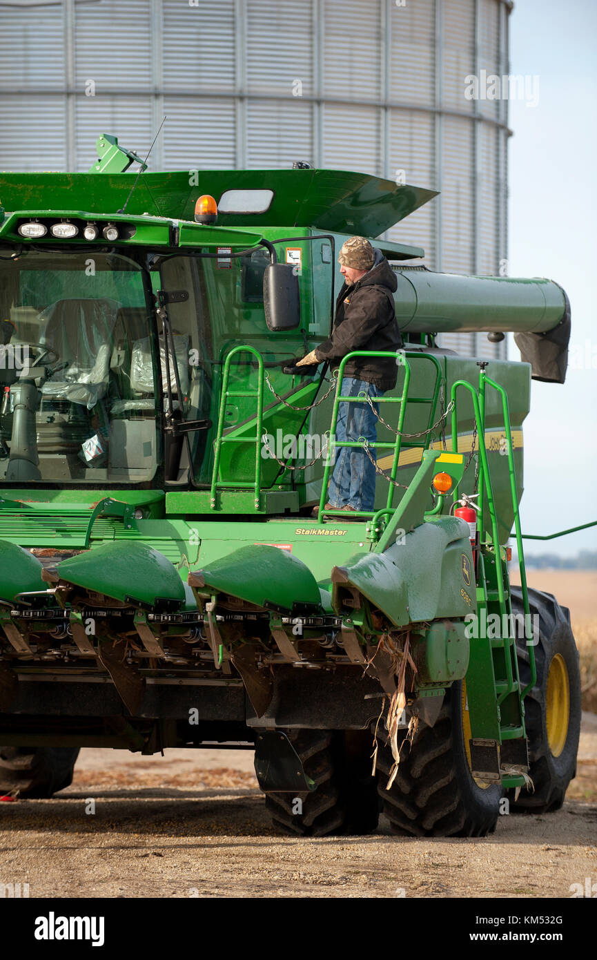 Imprenditore e lavoratori pulire UNA MIETITREBBIA JOHN DEERE prima di uscire per la raccolta di mais in una fattoria in UTICA, Minnesota. Foto Stock