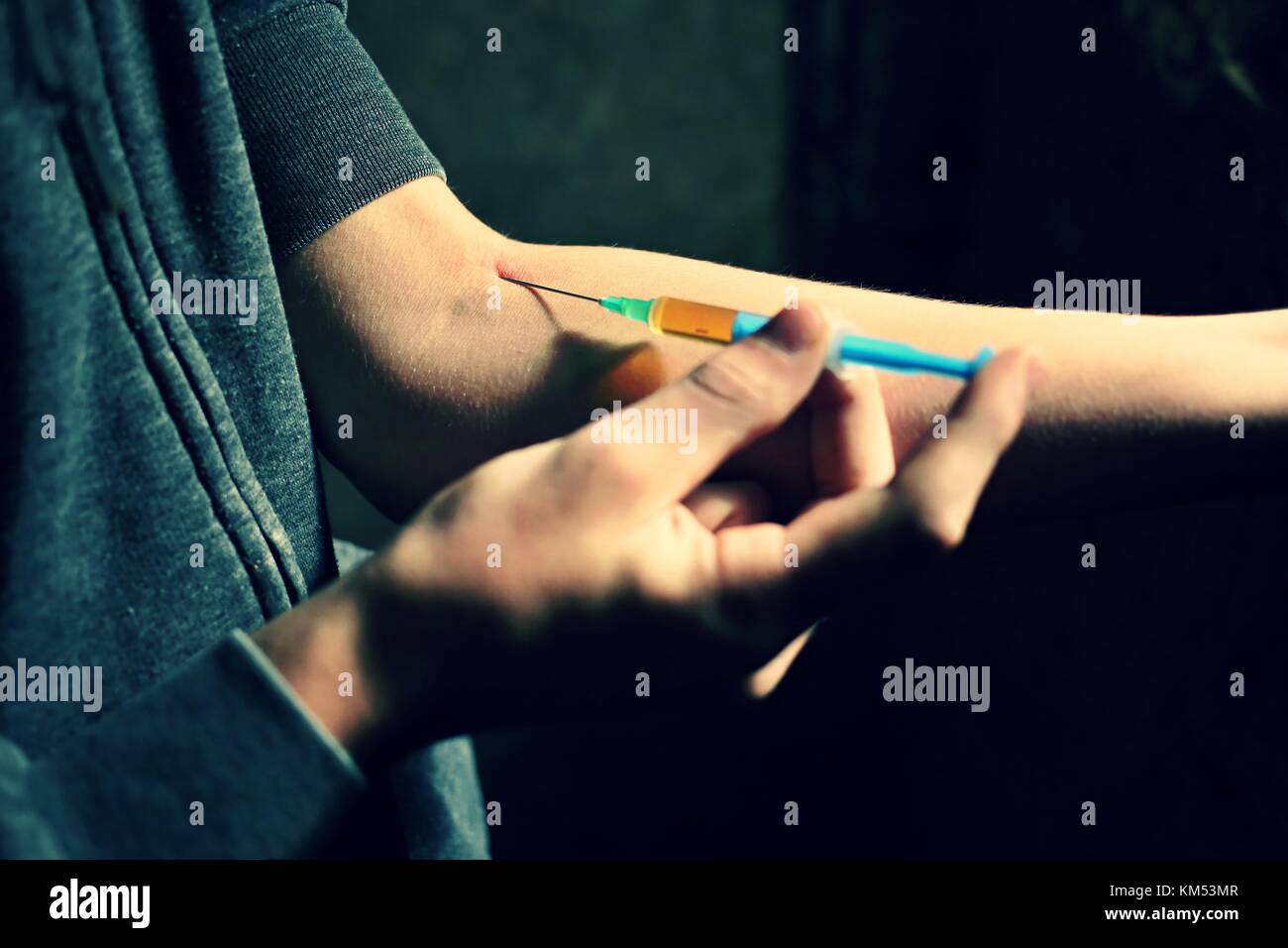 Uomo droga addicted l'iniezione di eroina nel suo braccio. farmaci concetto concetto di malattia. tossicodipendente uomo con siringa tramite farmaci.tema scuro. Foto Stock