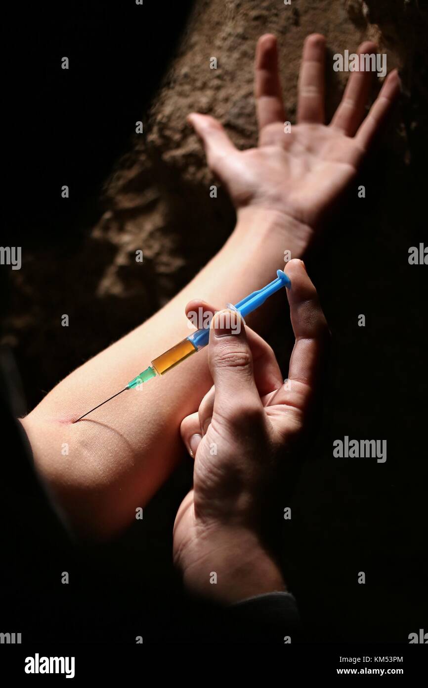 Uomo droga addicted l'iniezione di eroina nel suo braccio. farmaci concetto concetto di malattia. tossicodipendente uomo con siringa tramite farmaci.tema scuro. Foto Stock
