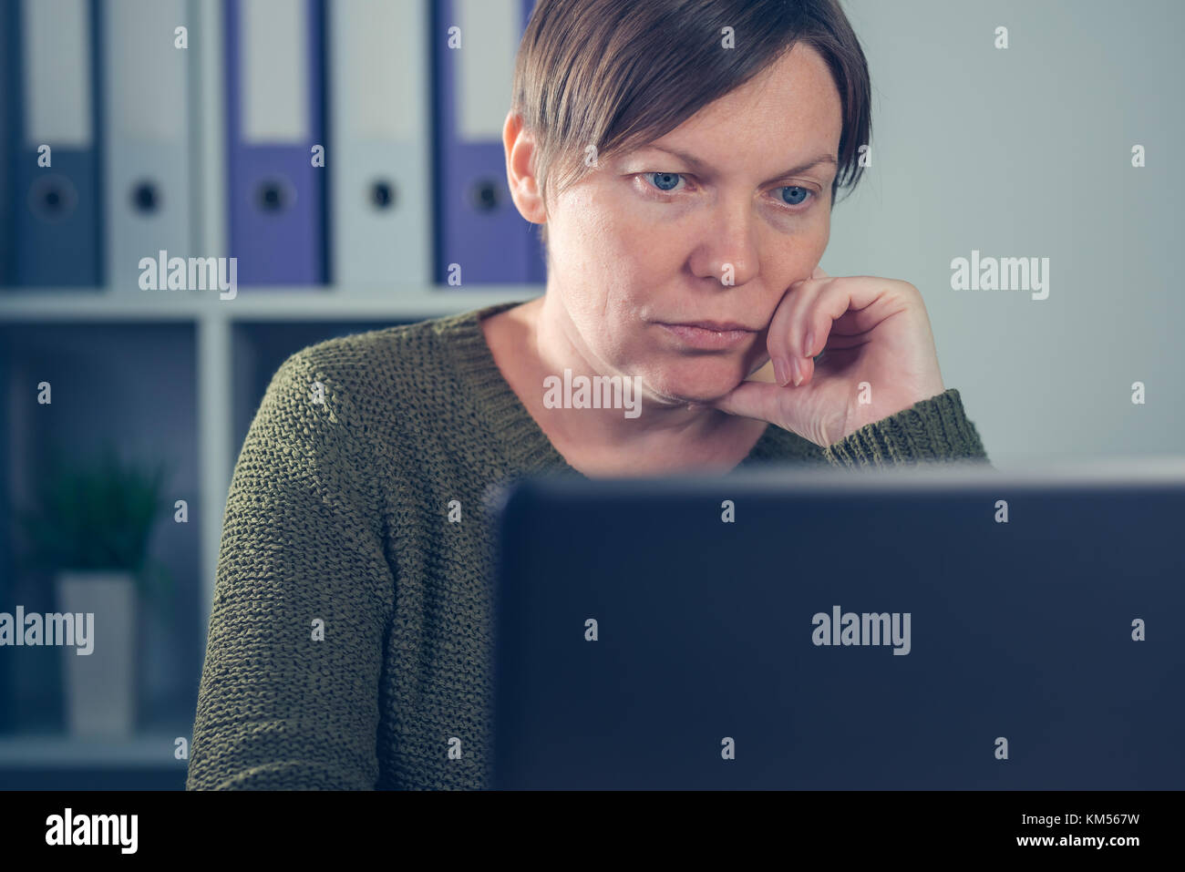 Femmina gravi freelancer lavorando sul computer portatile in ufficio a casa del suo piccolo business start up company Foto Stock