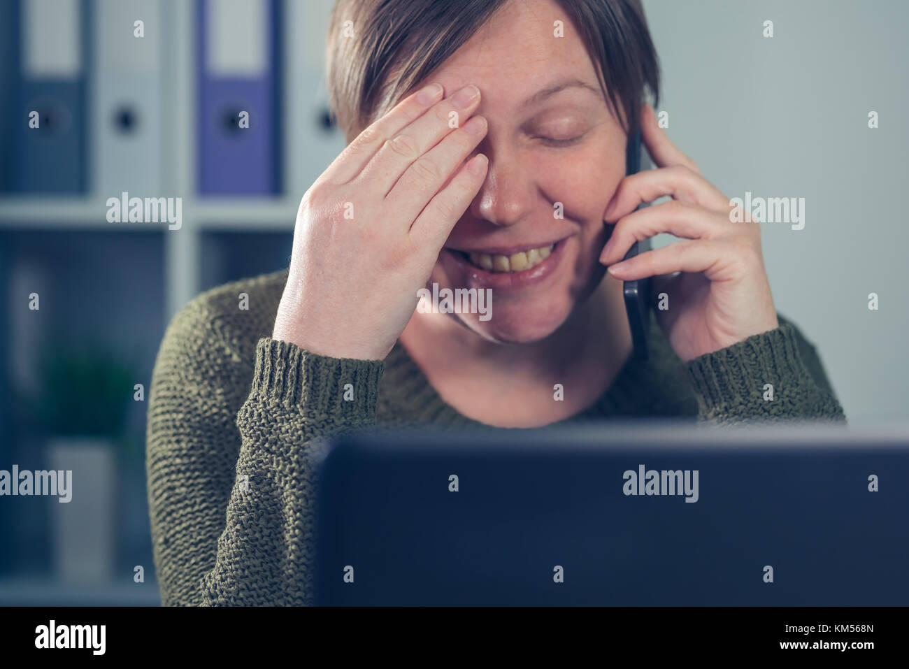 Stanco esausto freelancer femmina parlando al telefono mobile dalla sua propria start up business home office Foto Stock