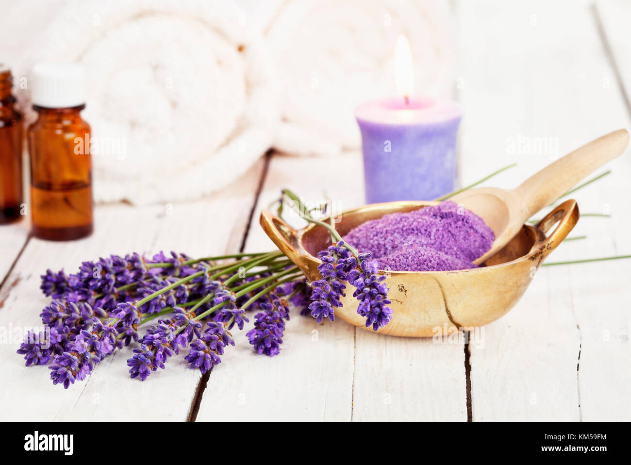 Fiori di lavanda, sale da bagno, olio da massaggio, candele profumate e asciugamani rustico sfondo bianco, alta immagine chiave Foto Stock