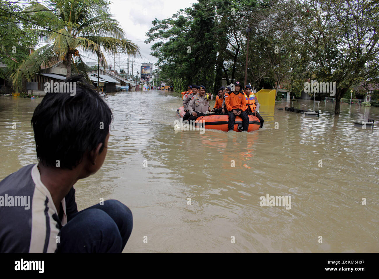 Aceh Utara, Aceh, Indonesia. 4 dicembre 2017. Una squadra di soccorritori ha visto entrare in città con una barca gonfiabile. La Regional Disaster Management Agency (BPBD) insieme alla comunità ha contribuito a evacuare i residenti ancora intrappolati dalle inondazioni in insediamenti densamente popolati nel distretto di North Aceh, provincia di Aceh, Indonesia. Condizioni di forte pioggia e forti venti hanno causato inondazioni da pozze di fiumi fino a 1,5 metri verso insediamenti densamente popolati nella provincia di Aceh. Crediti: Maskur Has/SOPA/ZUMA Wire/Alamy Live News Foto Stock