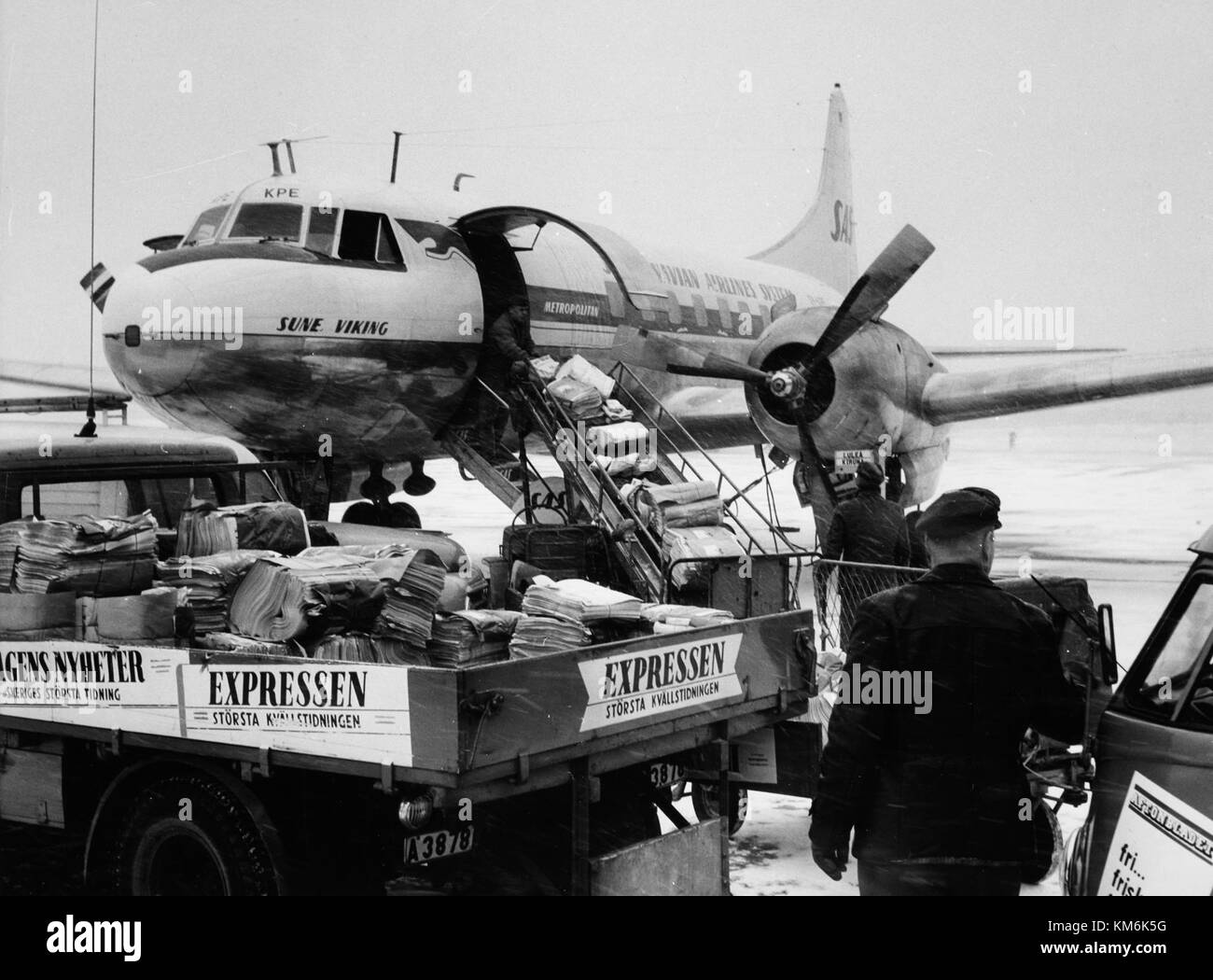 Il SAS Convair CV 440 Metropolitan è un aereo di stanza presso l'aeroporto di Bromma, impegnato nel caricamento di giornali e poste. Questa immagine cattura un momento nella storia dell'aviazione, evidenziando il suo ruolo nel trasporto aereo e nella logistica durante la metà del XX secolo. Foto Stock