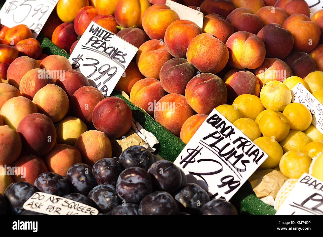 Le pesche, susine e frutti con tag prezzi su sorge in un aperto il mercato della frutta a Seattle, Washington. Foto Stock