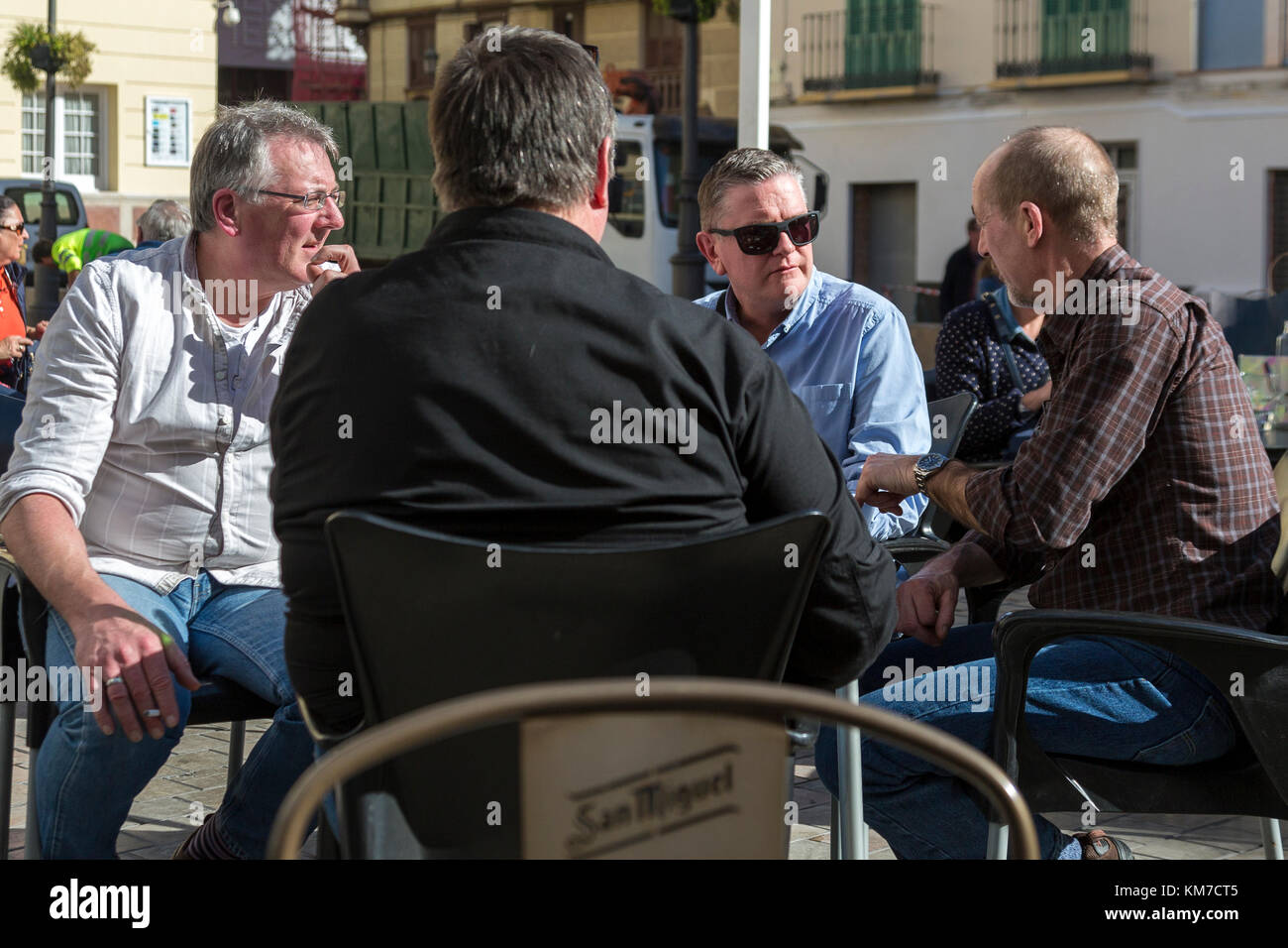 Gruppo di 4 mezza età uomini parlando a un tavolo del bar a Malaga Spagna Foto Stock