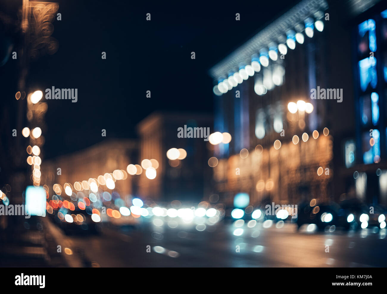 Città sfocata di notte. Bokeh di fondo. Bellissimo sfondo astratto con edifici sfocati, automobili, luci della città, le persone. Colorato sfondo bokeh di fondo con urban Foto Stock