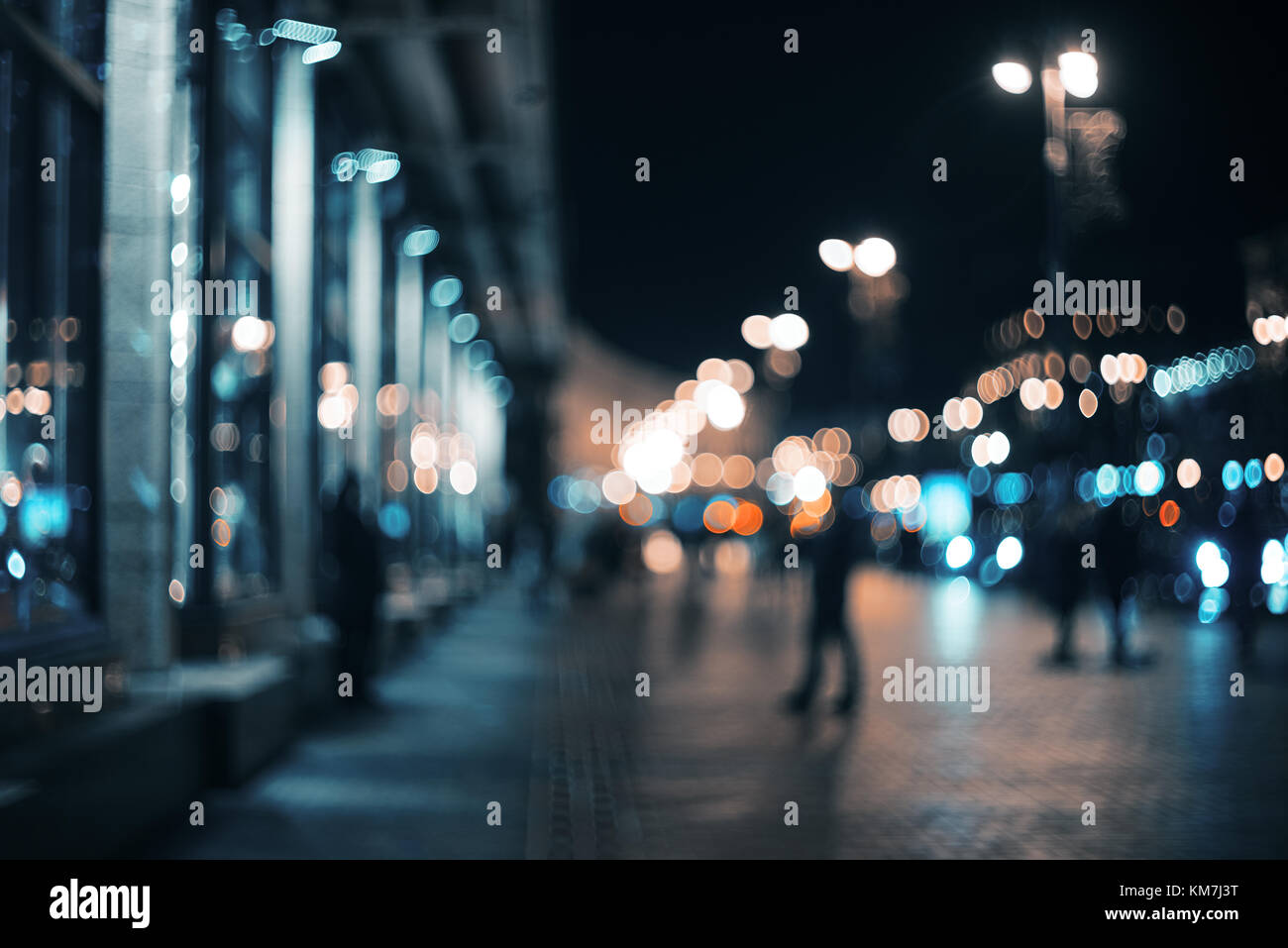 Città sfocata di notte. Bokeh di fondo. Bellissimo sfondo astratto con edifici sfocati, automobili, luci della città, le persone. Colorato sfondo bokeh di fondo con urban Foto Stock