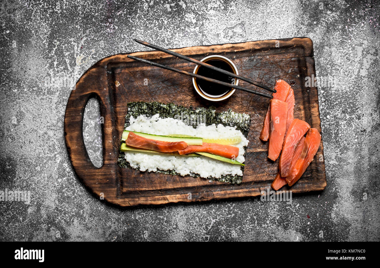 Il cibo giapponese. Cucina tradizionale rotoli con piatti a base di frutti di mare freschi. su sfondo rustico. Foto Stock