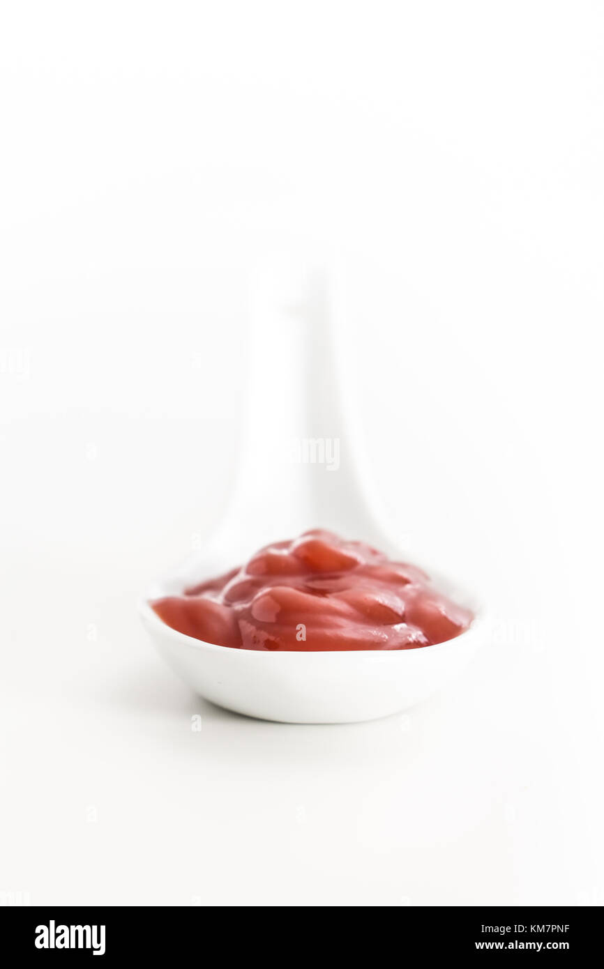 Cremosa salsa rossa in ceramica bianca cucchiaio, su sfondo bianco. Foto Stock