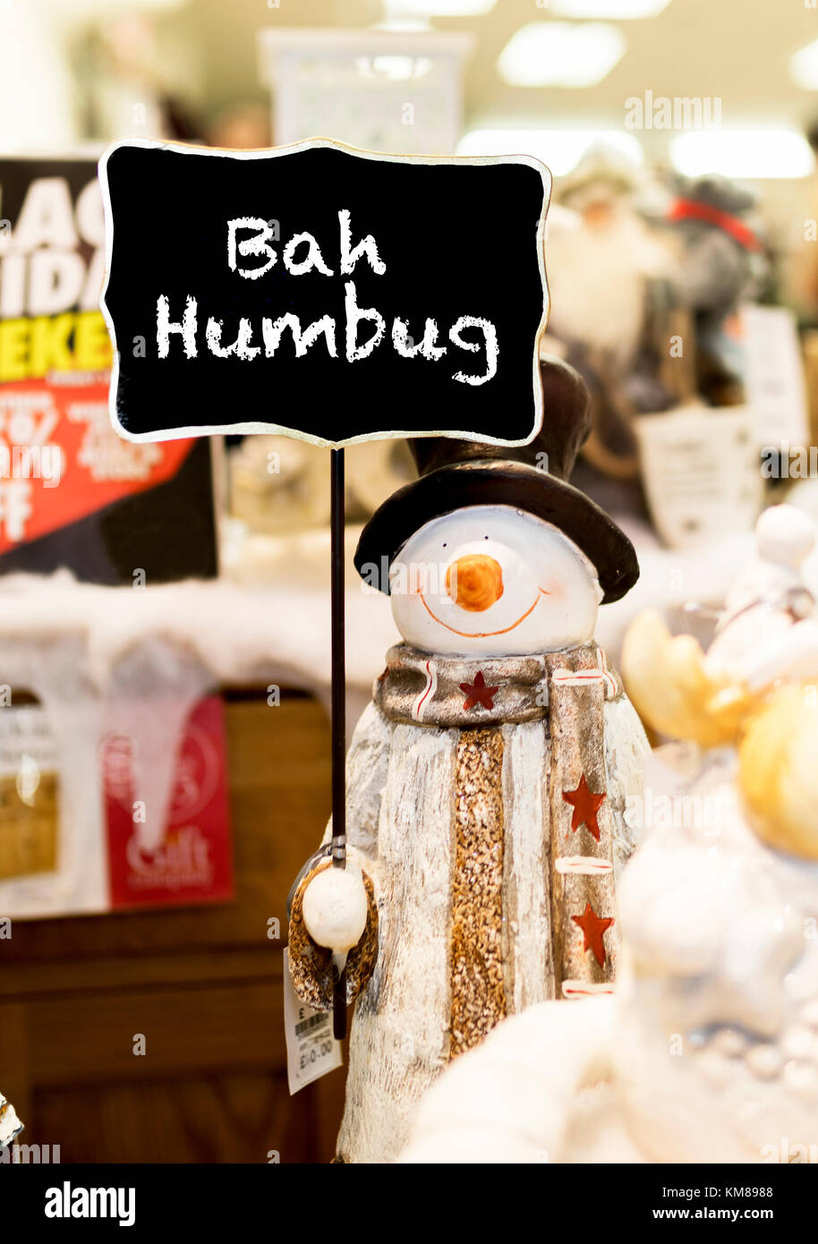Pupazzo di neve ornamentali waring una sciarpa coat e un top hat tenendo premuto fino a Bah Humbug firmare in un negozio di Natale nel Regno Unito Foto Stock