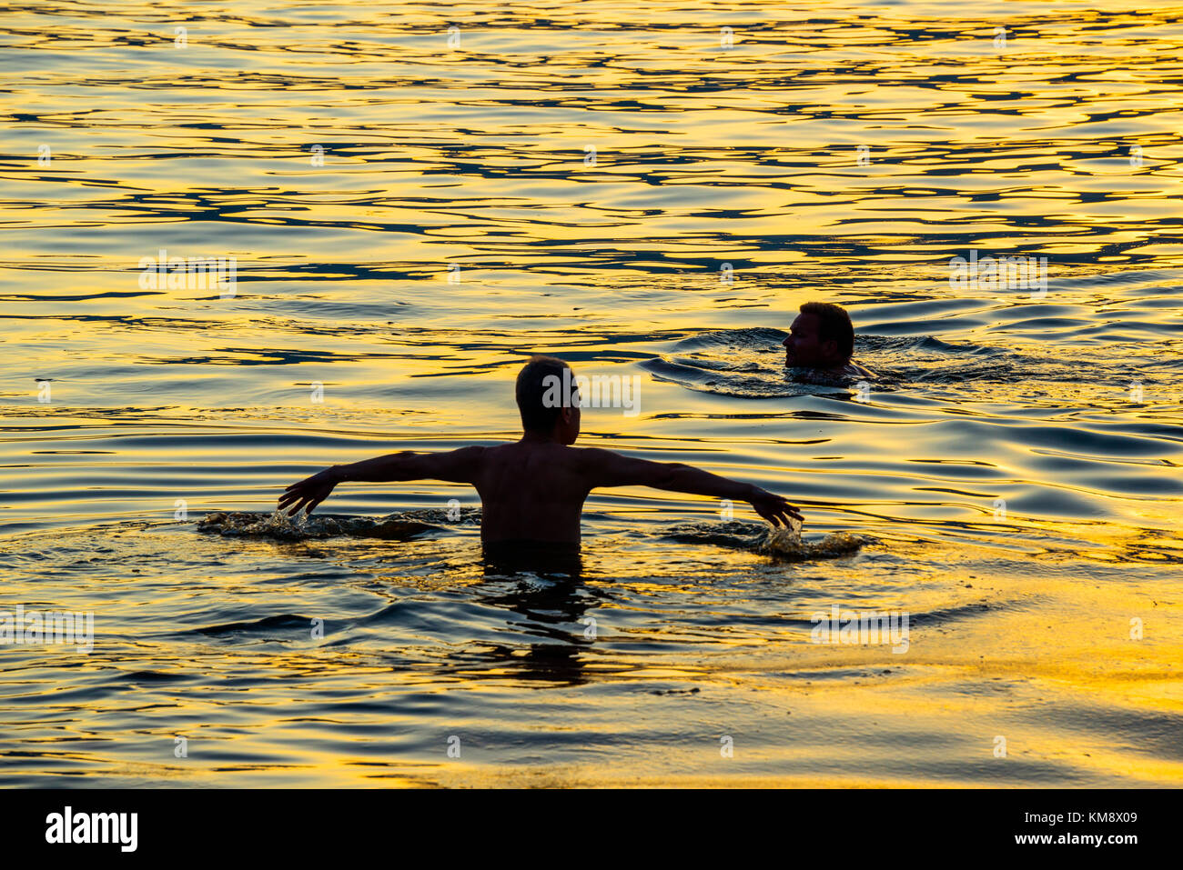 Due nuotatori al tramonto sul mare della cina del sud, Repulse Bay, Hong kong, luce dorata Foto Stock