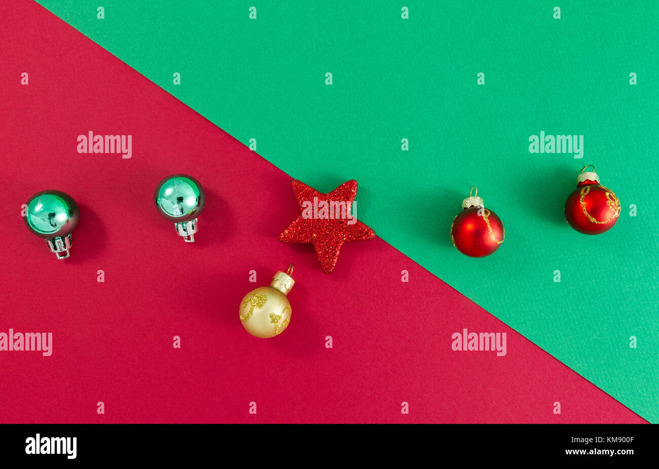 Stella di natale e le sfere sul verde e Sfondo rosso vista dall'alto. stile minimalista. separazione diagonale in alto a sinistra a in basso a destra Foto Stock