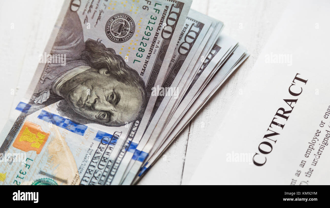 Contatto e una pila di banconote di un centinaio di dollari. Foto Stock
