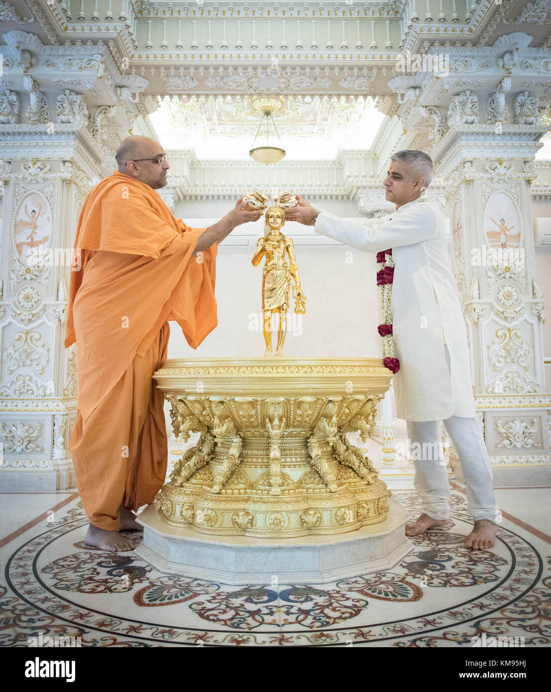 Sindaco di Londra Sadiq Khan si versa acqua santa su una statua di Swami Narayan con Swami Sadhu Gnanmunidas (sinistra) durante una visita al tempio di Akshardham a Delhi come parte dei suoi quattro giorni di viaggio in India. Esso è stato costruito dalla stessa setta di induismo che ha costruito il tempio a Neasden, a nord ovest di Londra. Foto Stock