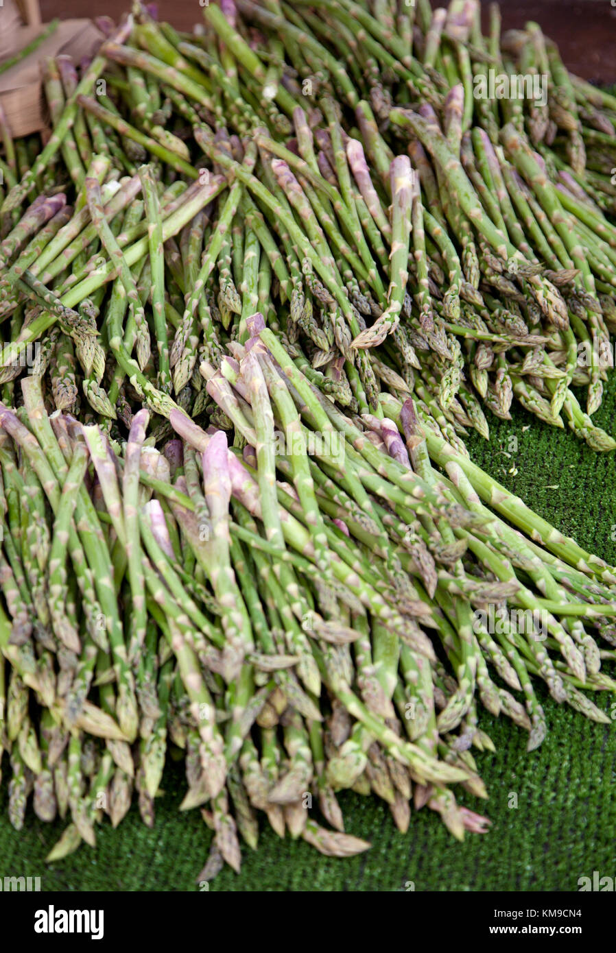 Un accatastate, allentati pila di freschi Asparagi raccolti su un mercato in stallo close up Foto Stock