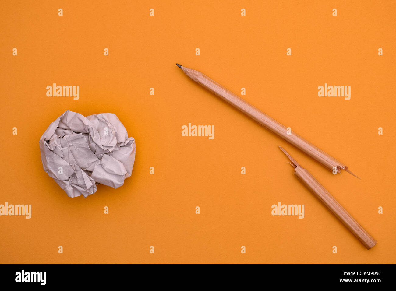 Rotture di matita e carta sgualcita sfera su uno sfondo giallo. close up. Foto Stock