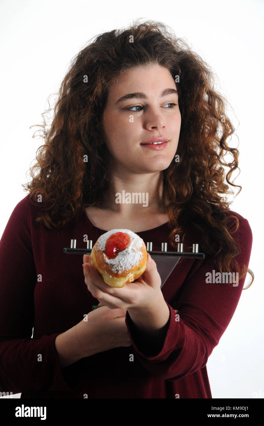 Festa ebraica Hanukkah - bella donna con dolci sufganiyot (ciambelle) e menorah Foto Stock