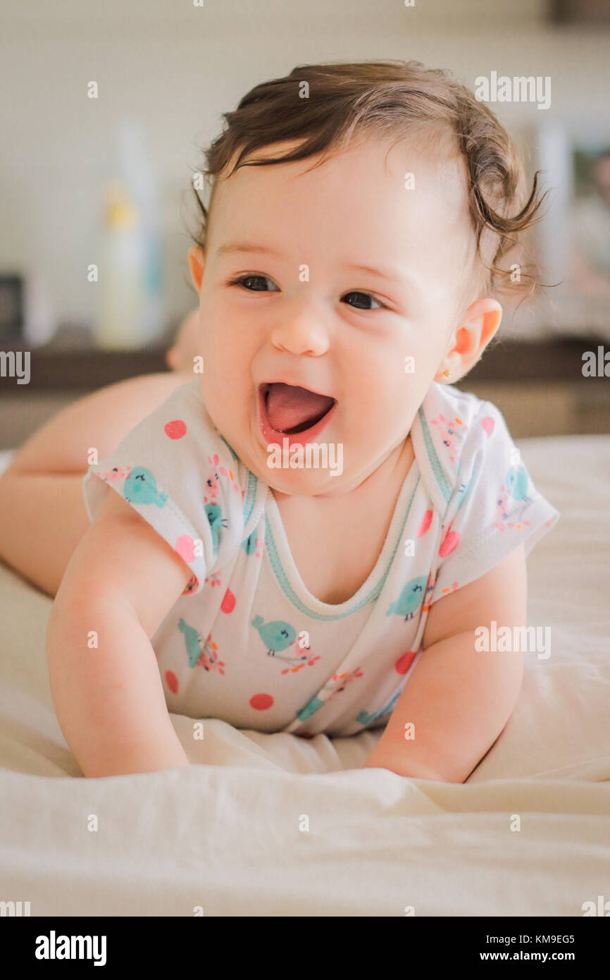 Ritratto di un sorridente bambina giacente sulla sua parte anteriore Foto Stock