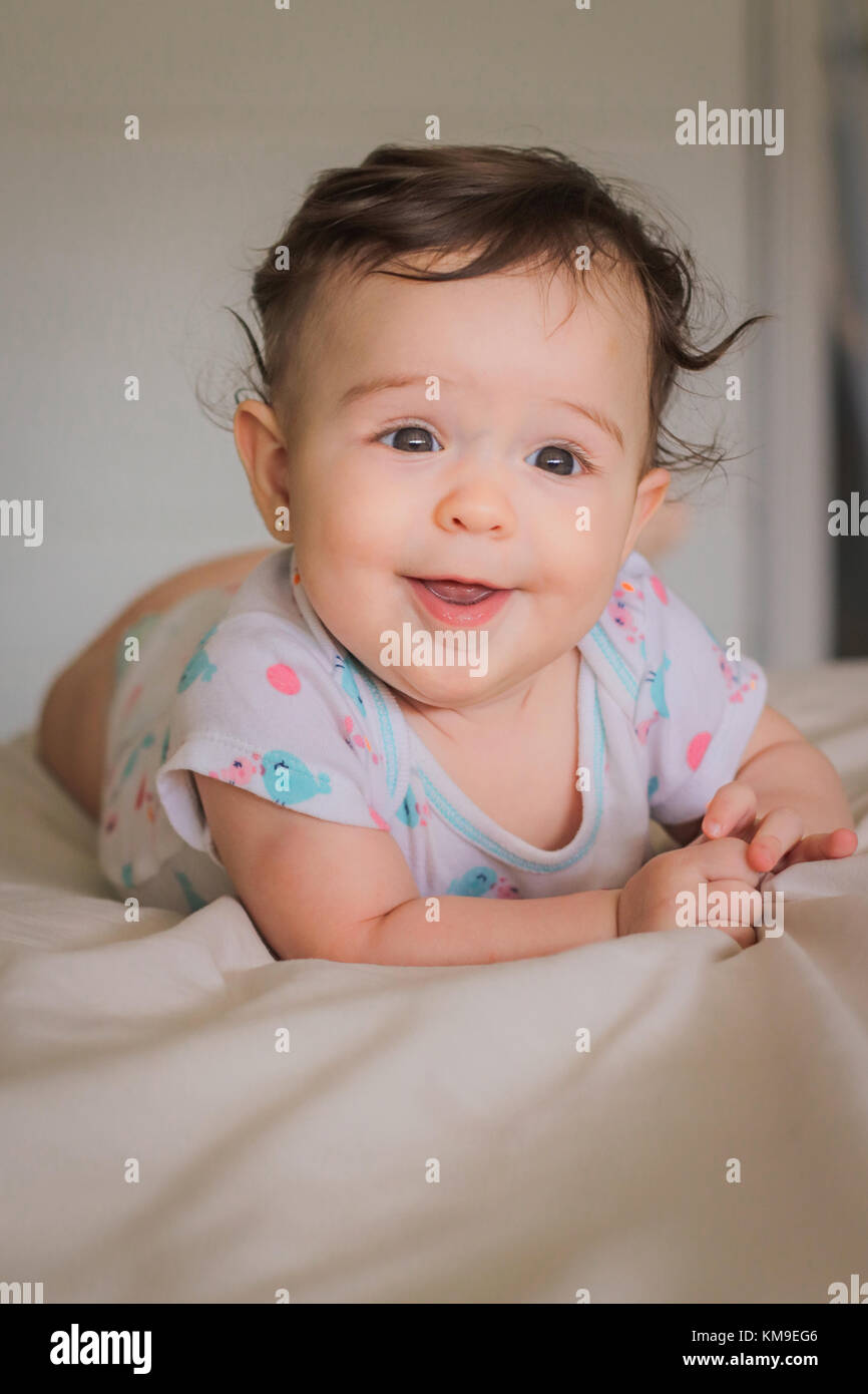 Ritratto di un sorridente bambina giacente sulla sua parte anteriore Foto Stock