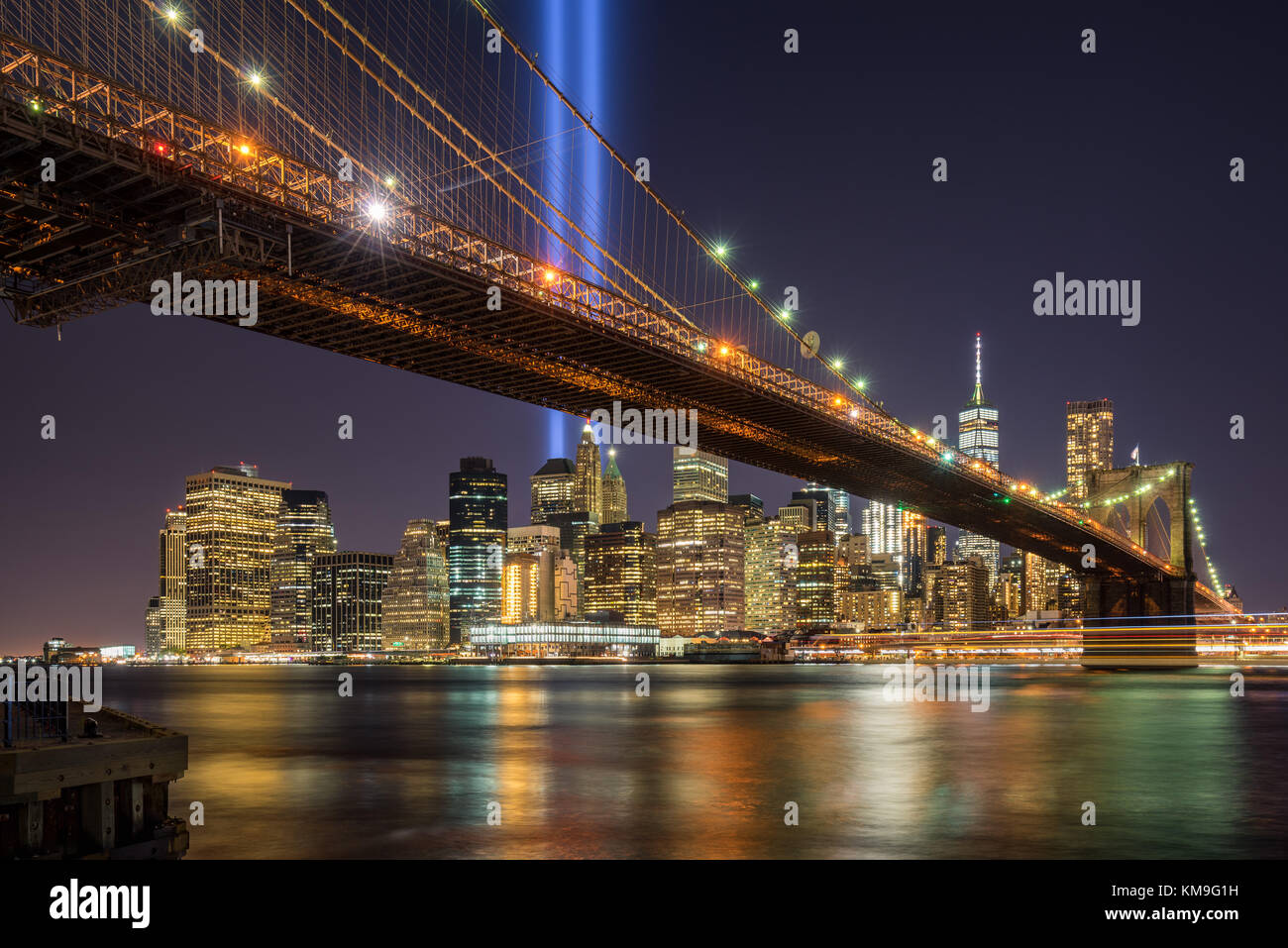 Omaggio in luce con il ponte di Brooklyn e la skycrapers di Lower Manhattan. Il quartiere finanziario di New York City Foto Stock