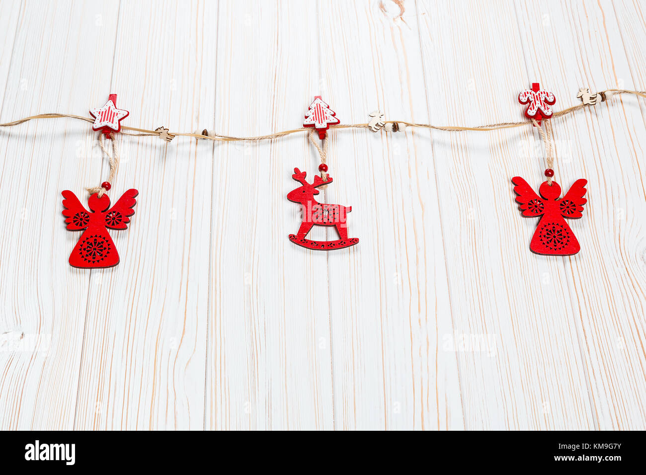 Natale rosso in legno giocattoli nella forma di un cervo e un angelico fune su un bianco sullo sfondo di legno. bellissimo messaggio di saluto festivo card con spazio libero Foto Stock