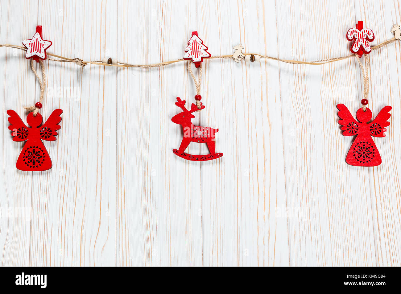 Natale rosso in legno giocattoli nella forma di un cervo e un angelico fune su un bianco sullo sfondo di legno. bellissimo messaggio di saluto festivo card con spazio libero Foto Stock