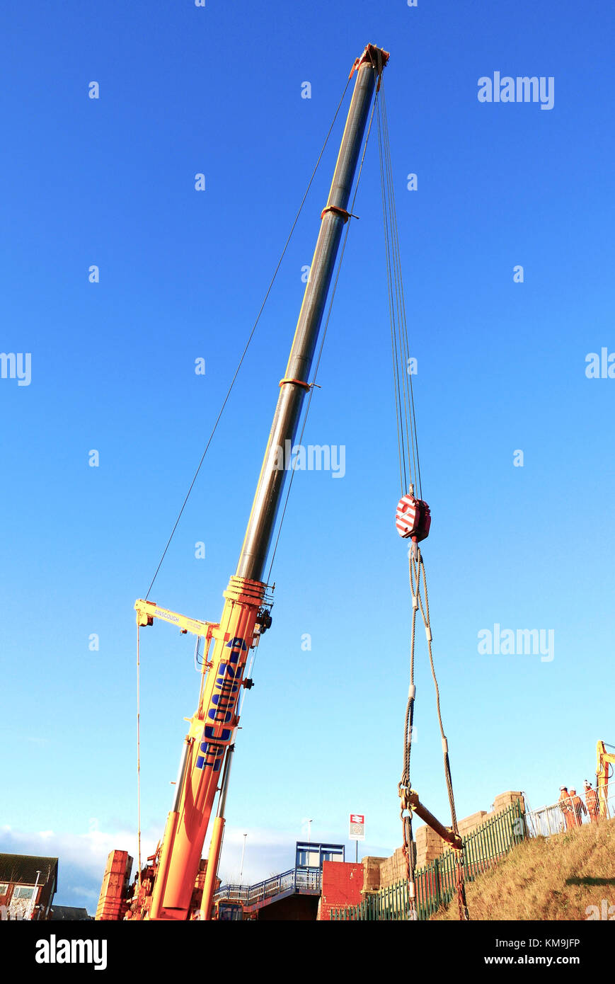 Gigante giallo gru contro il cielo blu lavorando sul ponte ferroviario miglioramenti,Blackpool, Lancashire, Regno Unito Foto Stock