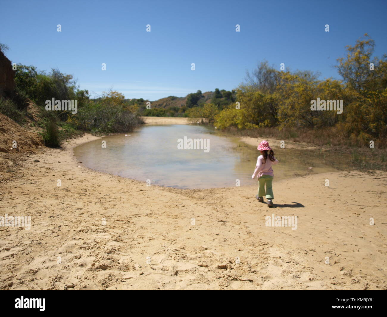 La ragazza che si avvicinano ad un piccolo lago su una duna di sabbia vicino al mare Foto Stock