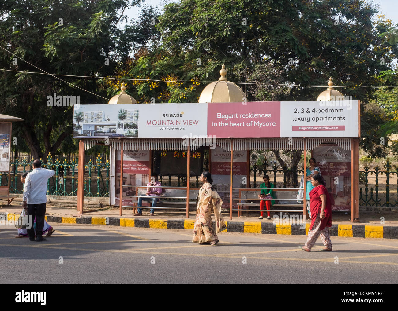 Persone in attesa alla fermata del bus, Mysore, Karnataka, India. Foto Stock