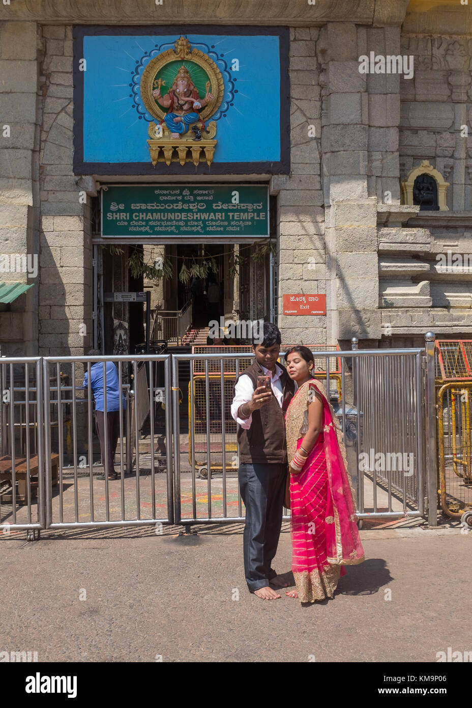 Giovani indiani giovane in piedi e tenendo selfie davanti di Shri chamundeshwari tempio a Mysore, mysuru, Karnataka, India. Foto Stock