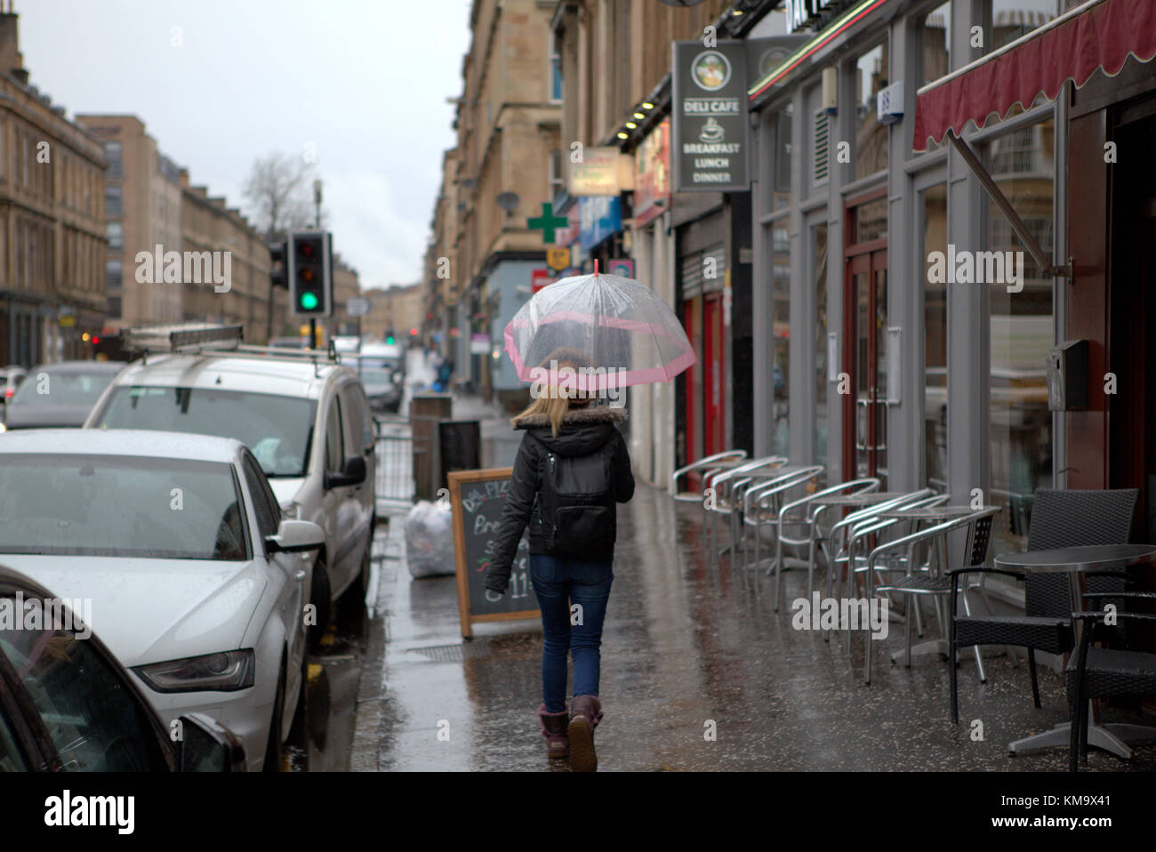 Ragazza con ombrello Rainy Day Wet argyle Street a Finnieston, Glasgow, Regno Unito Foto Stock