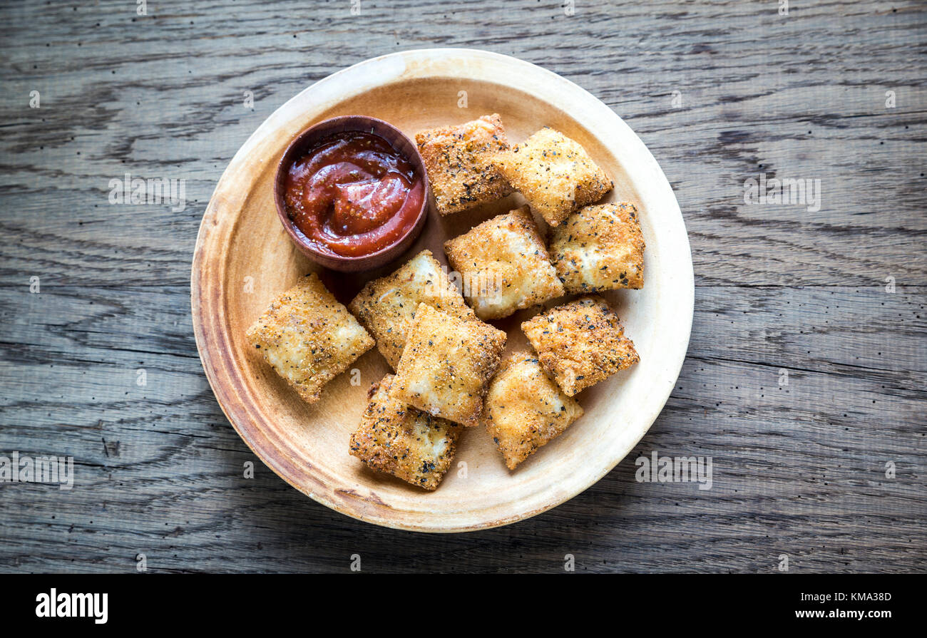 Piastra con ravioli fritti sulla tavola di legno Foto Stock