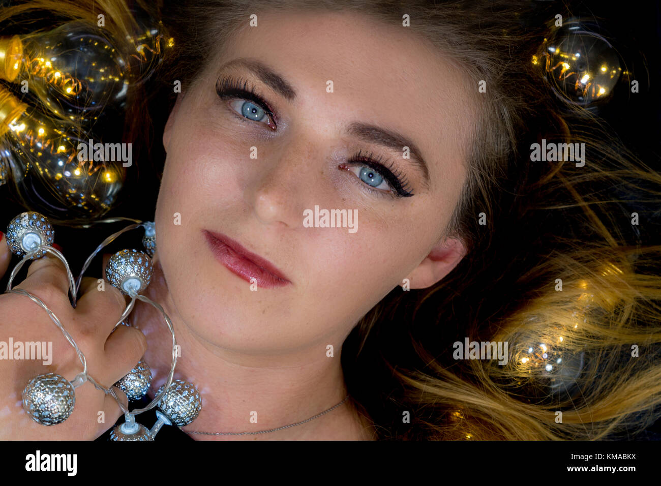 Una giovane donna è circondata da luci Foto Stock